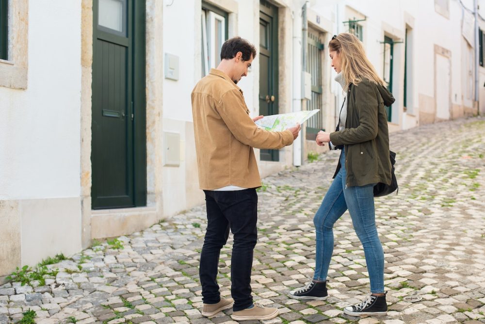 Man and women in street with map - Its ok to use a map