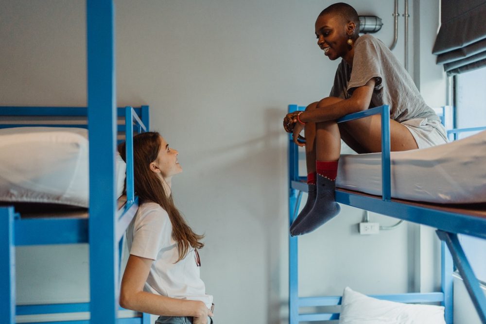 Two women talking in a hostel - Meeting people while traveling.