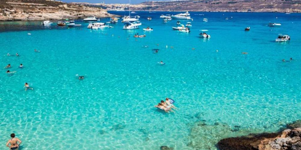 People swimming in blue lagoon at Comino - Malta